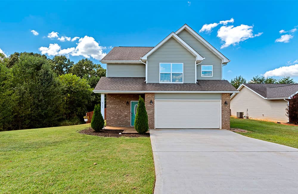 a house with a driveway and trees